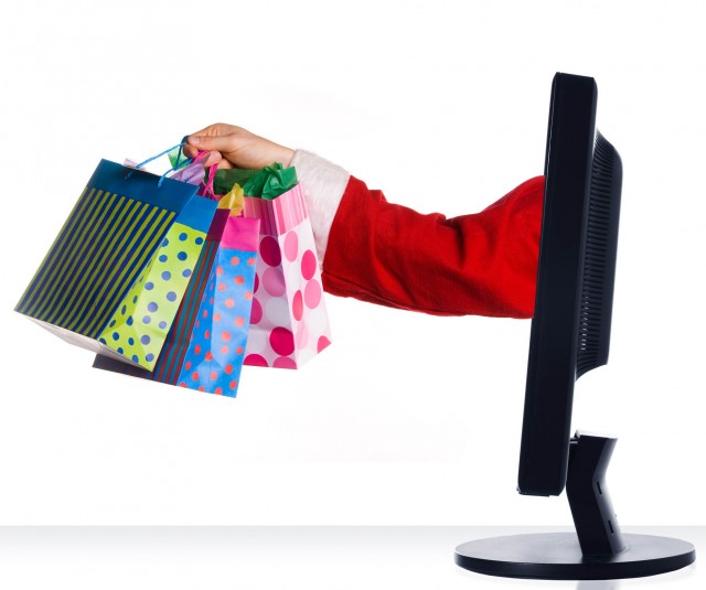 santa clause sticking hand out of monitor with gifts